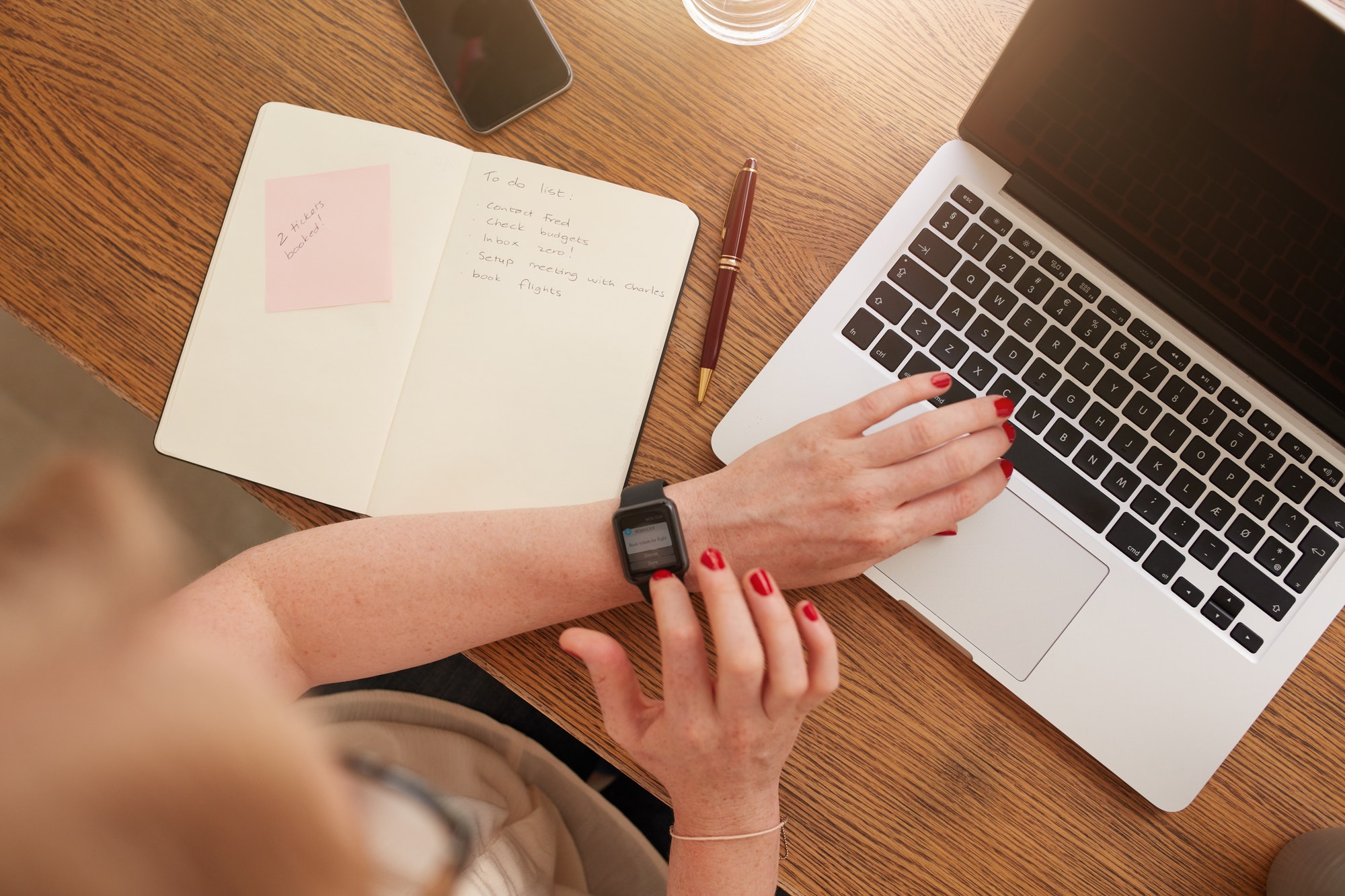 Woman sitting at her desk and using smartwatch