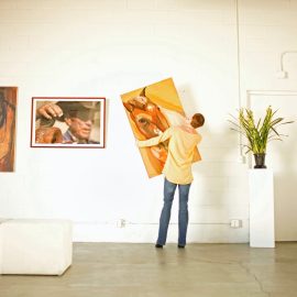 Owner hanging art in gallery